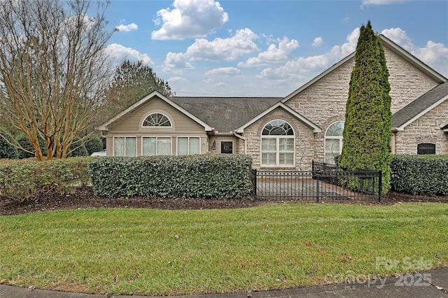 view of front facade with stone siding and a front lawn