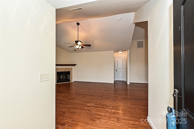 unfurnished living room with lofted ceiling, a fireplace, wood finished floors, visible vents, and a ceiling fan