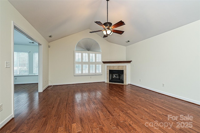 unfurnished living room with a healthy amount of sunlight, dark wood-style floors, visible vents, and a tile fireplace