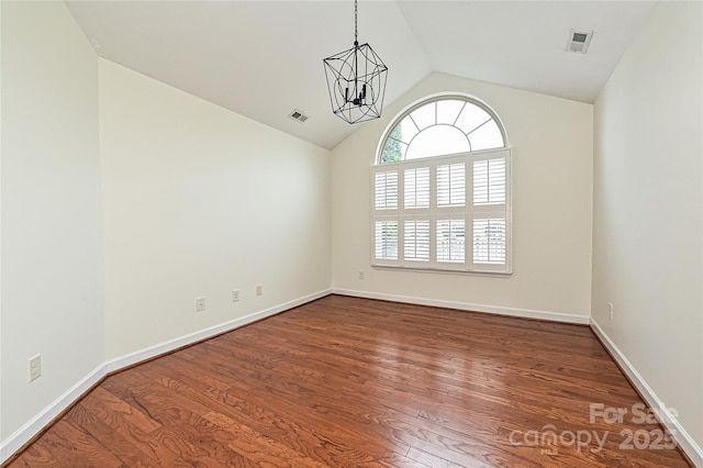 spare room featuring visible vents, a chandelier, and wood finished floors