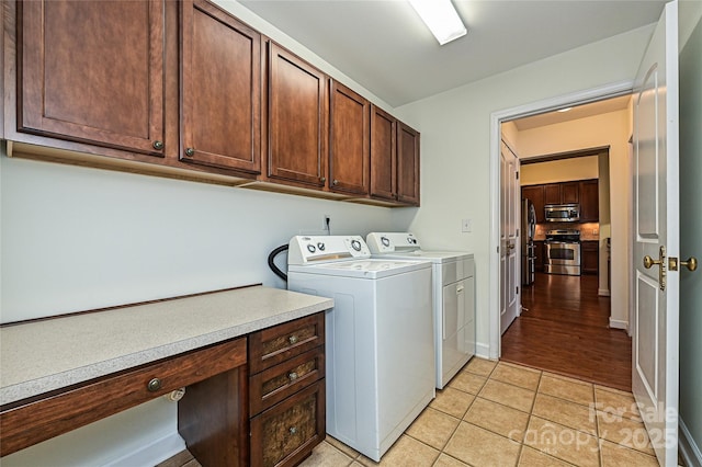 laundry room with light tile patterned floors, cabinet space, baseboards, and washer and dryer