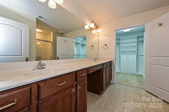 bathroom with double vanity, visible vents, a sink, and tile patterned floors