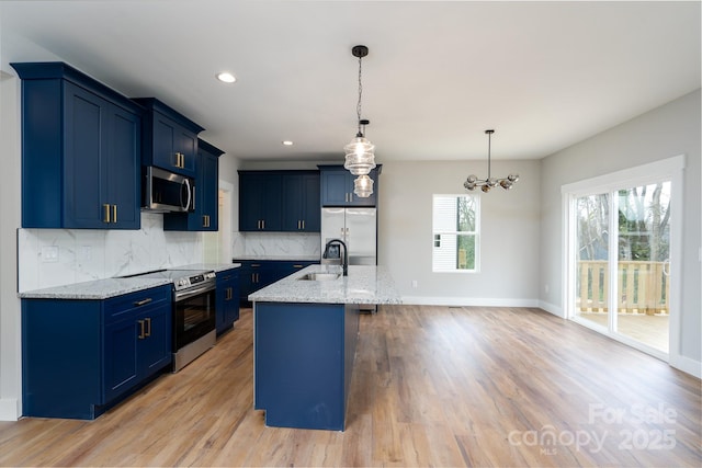 kitchen with decorative backsplash, light wood-style floors, appliances with stainless steel finishes, blue cabinetry, and a sink