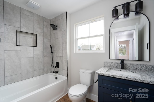 bathroom with washtub / shower combination, vanity, toilet, and baseboards