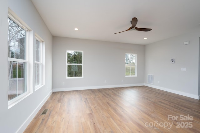 spare room with light wood-style flooring, visible vents, and baseboards