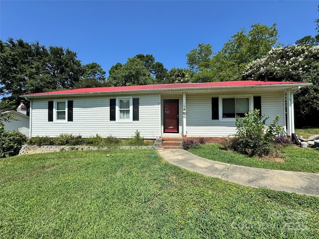 single story home featuring metal roof and a front lawn