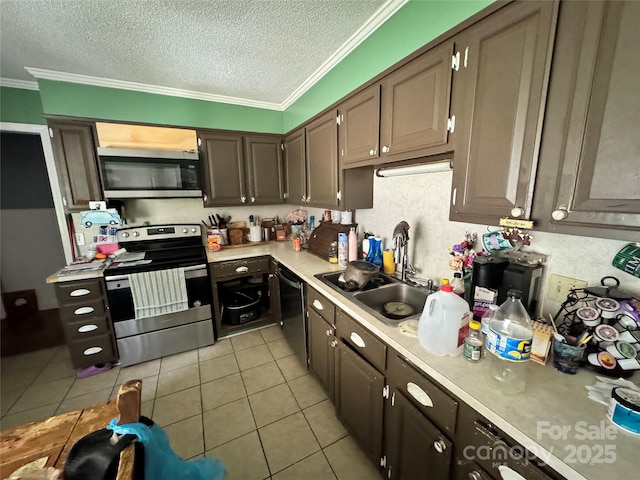 kitchen featuring ornamental molding, a sink, stainless steel appliances, light countertops, and light tile patterned floors