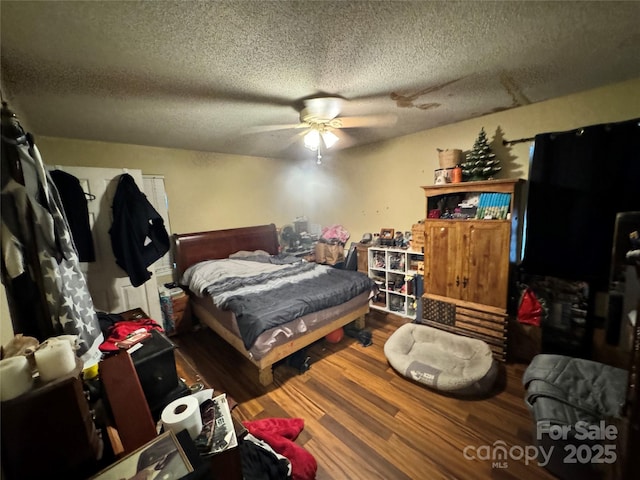 bedroom featuring a textured ceiling, ceiling fan, and wood finished floors