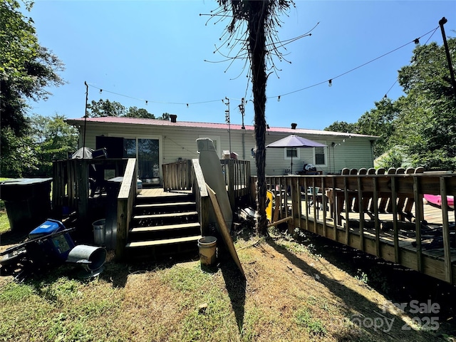 rear view of property featuring a deck and metal roof