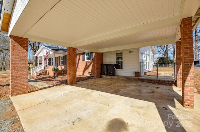 view of patio with driveway, fence, and a carport