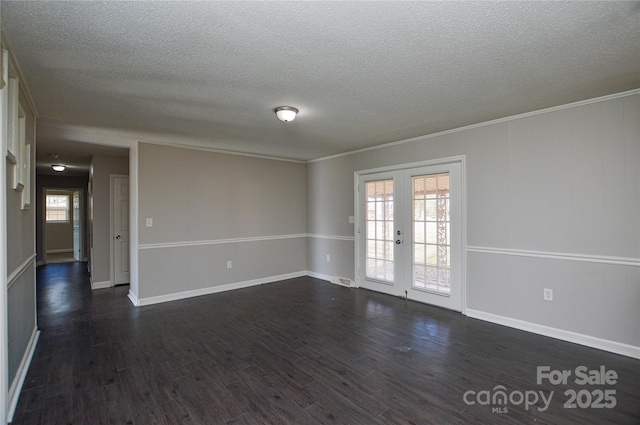 spare room with ornamental molding, french doors, a textured ceiling, and dark wood finished floors