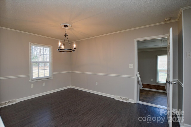 empty room with ornamental molding, dark wood-type flooring, plenty of natural light, and visible vents