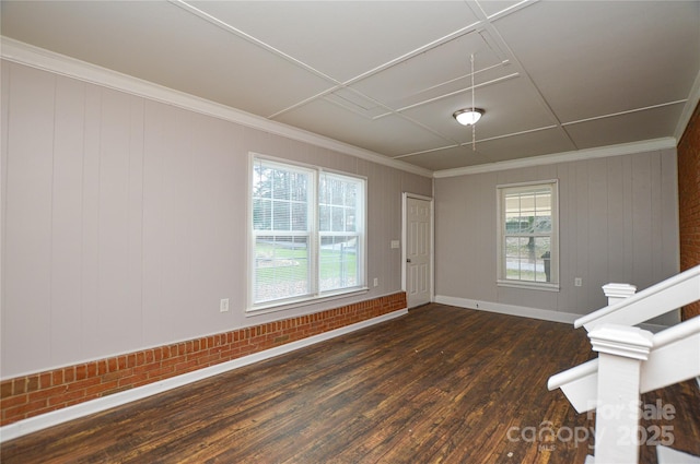 spare room with ornamental molding, attic access, dark wood finished floors, and baseboards