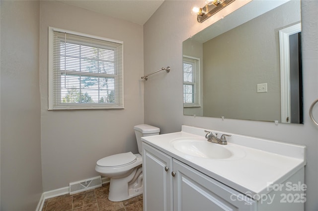 bathroom with toilet, baseboards, visible vents, and vanity