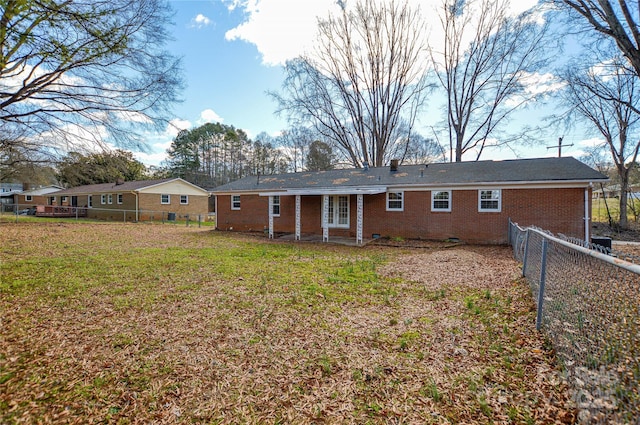 rear view of property featuring a yard, brick siding, crawl space, and a fenced backyard