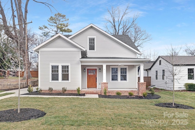 view of front of house with a porch, a front yard, and roof with shingles