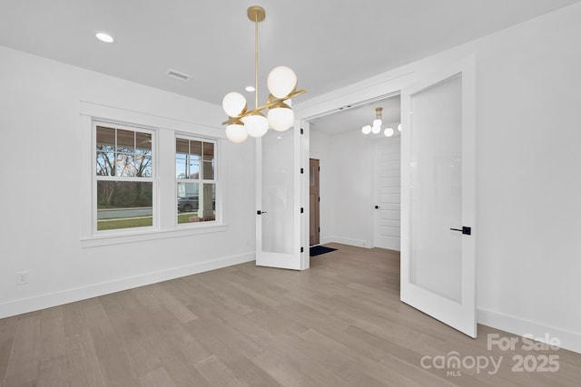 unfurnished dining area featuring recessed lighting, visible vents, wood finished floors, a chandelier, and baseboards