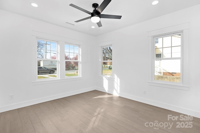 spare room with recessed lighting, visible vents, baseboards, and wood finished floors