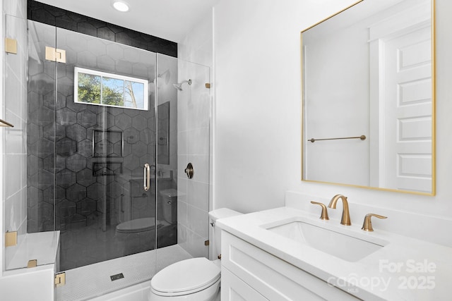 bathroom featuring vanity, a shower stall, and toilet