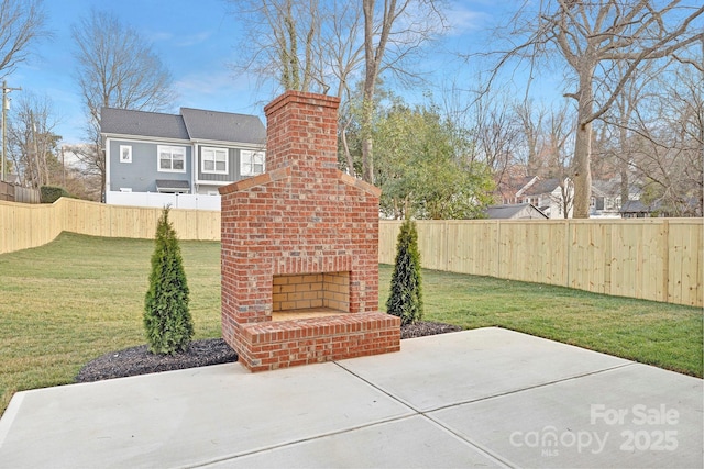 view of patio with an outdoor brick fireplace and a fenced backyard