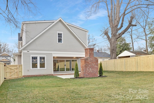 back of property featuring a gate, a fenced backyard, a lawn, and a chimney