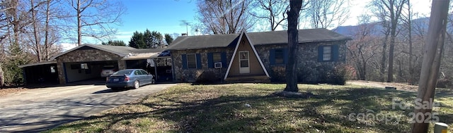 view of front of house with an attached garage, concrete driveway, stone siding, and a front yard