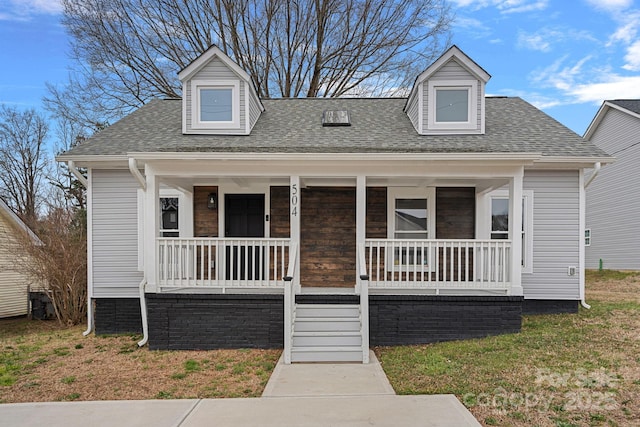 cape cod home featuring a porch, a front lawn, and roof with shingles