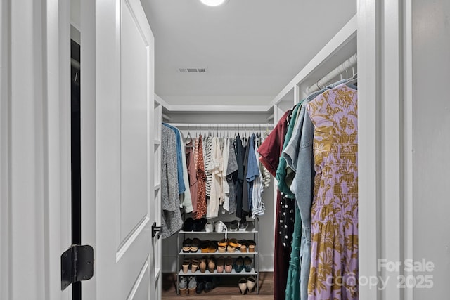 walk in closet with wood finished floors and visible vents