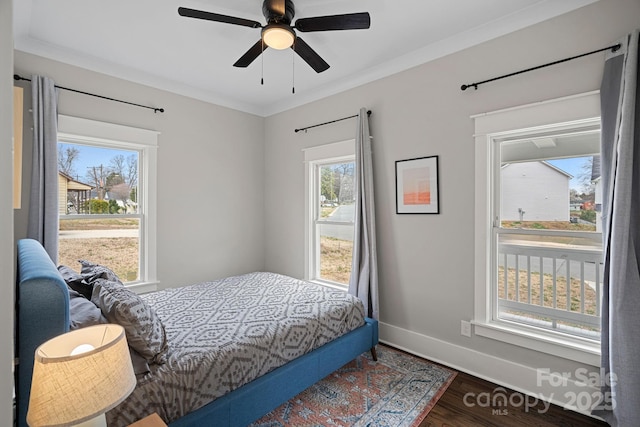 bedroom featuring a ceiling fan, wood finished floors, baseboards, and ornamental molding