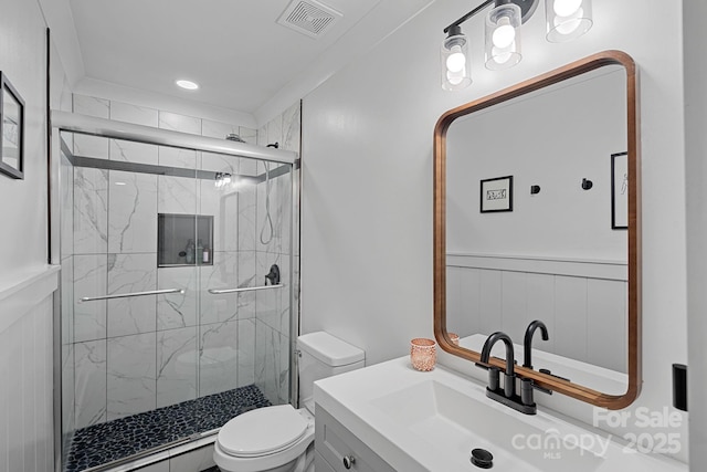 bathroom with a marble finish shower, visible vents, toilet, and vanity