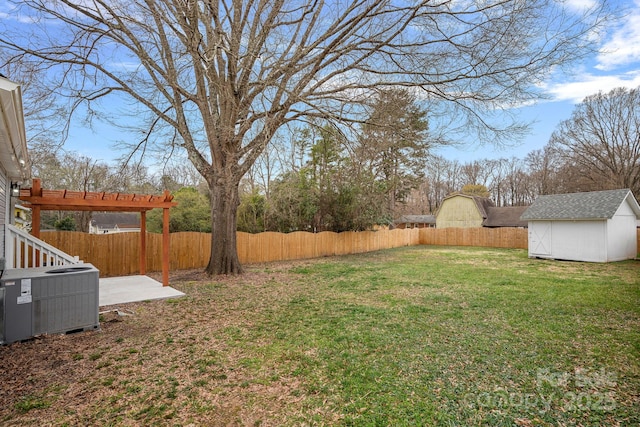 view of yard featuring an outbuilding, a shed, a fenced backyard, and central AC