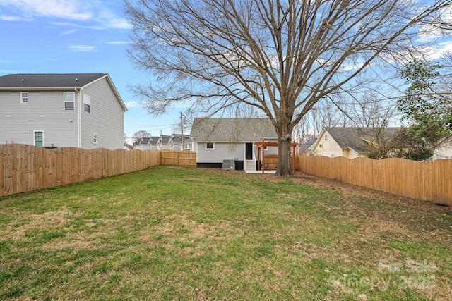 view of yard with cooling unit, an outbuilding, and a fenced backyard