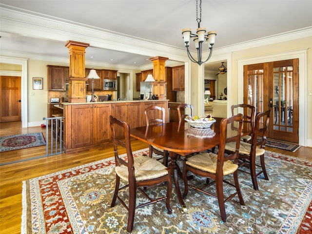 dining space featuring ornamental molding, wood finished floors, and an inviting chandelier