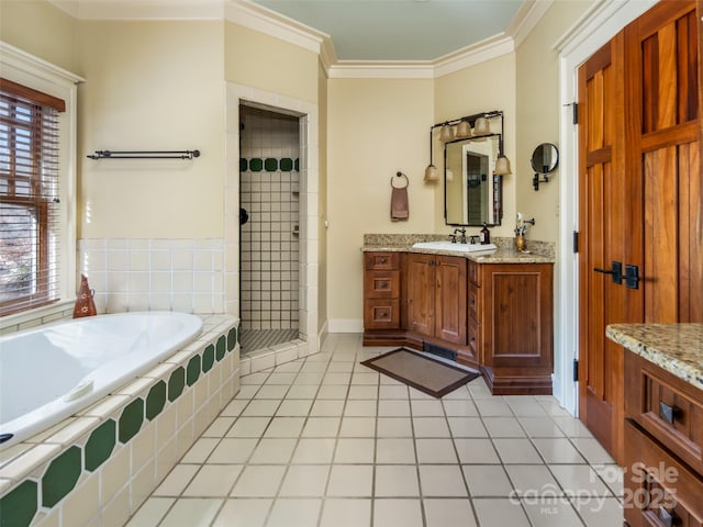 full bathroom featuring a stall shower, tile patterned floors, a garden tub, crown molding, and vanity