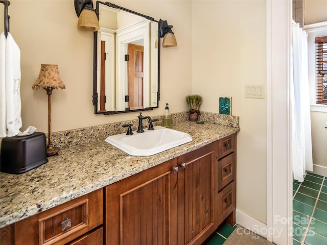 full bath featuring vanity and baseboards