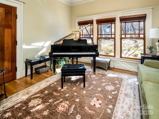 living area with crown molding, baseboards, and wood finished floors