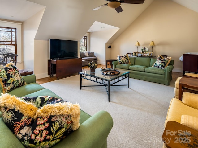 living area with lofted ceiling, ceiling fan, and baseboards