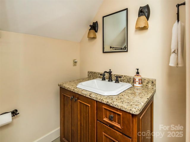 bathroom featuring lofted ceiling and vanity