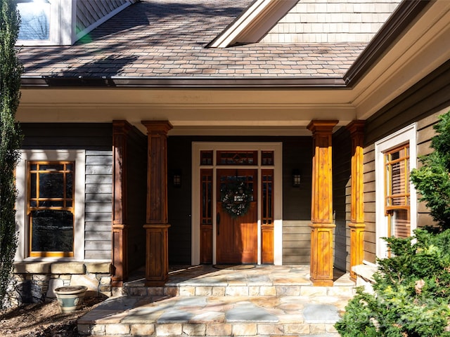 entrance to property featuring a porch and a high end roof