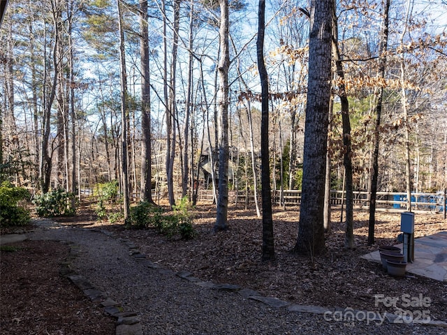 exterior space with fence and a forest view