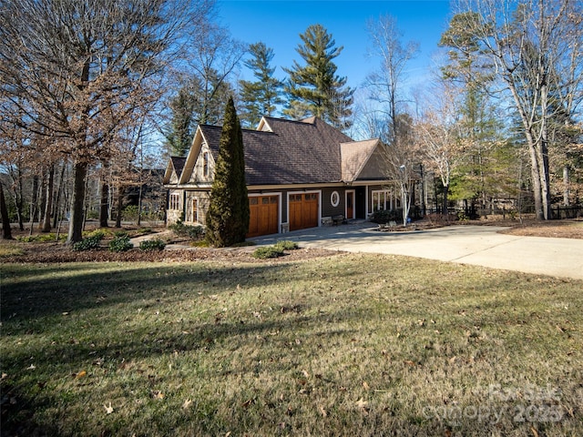 view of side of home with a garage, roof with shingles, a lawn, and driveway