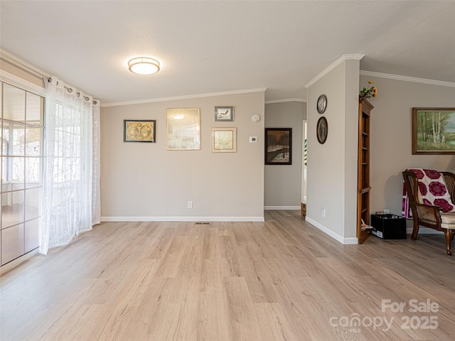 unfurnished room with baseboards, light wood-type flooring, and ornamental molding