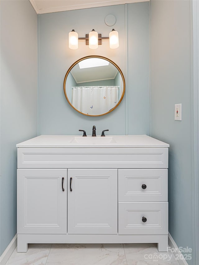 bathroom featuring marble finish floor, vanity, and baseboards