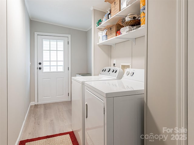 laundry area with washer and dryer, light wood-style flooring, laundry area, and crown molding