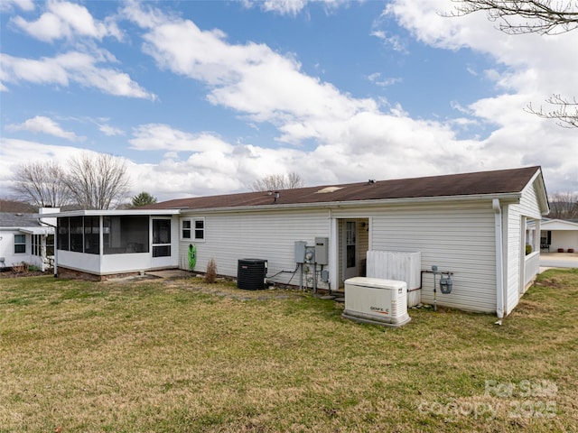 rear view of house featuring central AC, a yard, and a sunroom