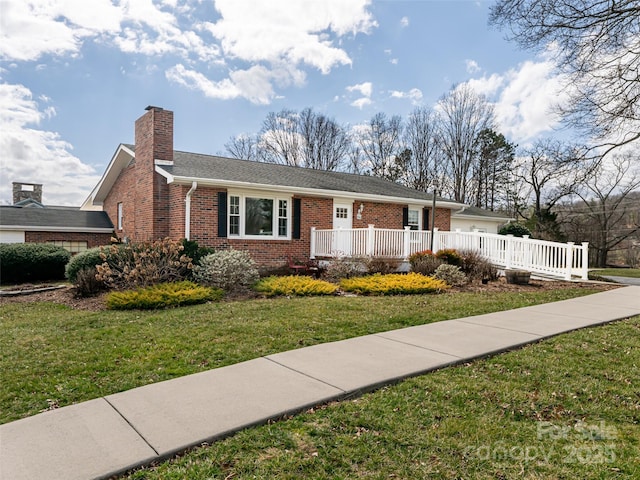 ranch-style house featuring brick siding, a chimney, and a front yard