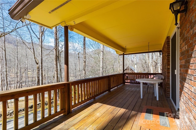 wooden terrace featuring a wooded view