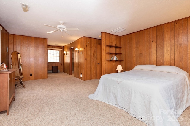 carpeted bedroom featuring arched walkways, wood walls, visible vents, and a ceiling fan