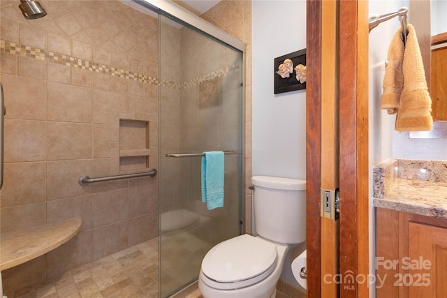 bathroom featuring a stall shower, vanity, and toilet