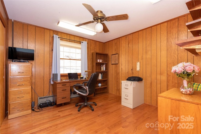 office with ceiling fan, light wood finished floors, a baseboard radiator, and wooden walls